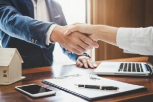 dettaglio di stratta di mani dopo aver firmato un contratto assicurativo