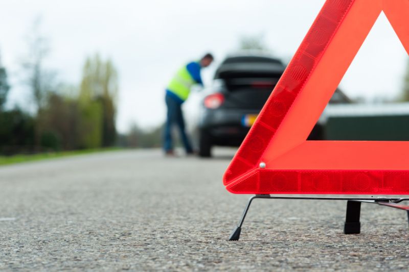 Soccorso stradale per auto in panne incluso nella polizza Unisind, con triangolo di emergenza su strada