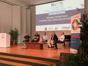 Immagine che mostra 5 persone durante un webinar. L'immagine proiettata dietro il palco rappresentata la descrizione del convegno unisind avvenuto il 25 giugno 2025