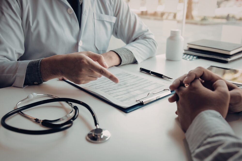 Consulenza su polizza sanitaria detraibile con medico e paziente durante la compilazione dei documenti.