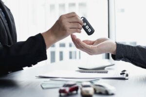 Consegna delle chiavi di un’auto durante la firma di un contratto di noleggio a lungo termine.