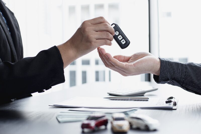 Consegna delle chiavi di un’auto durante la firma di un contratto di noleggio a lungo termine.