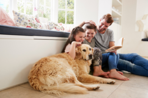 Famiglia con bambini e cane insieme nel soggiorno di casa
