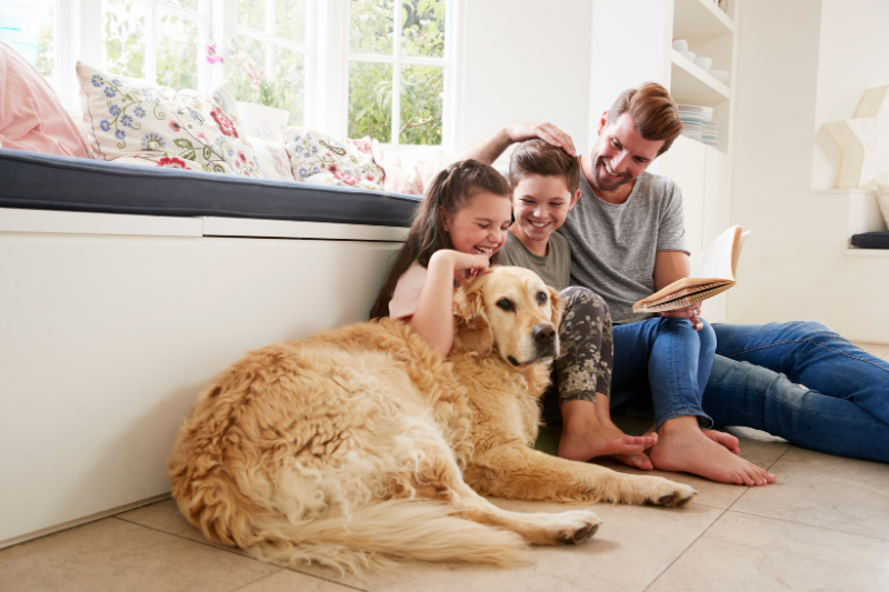Famiglia con bambini e cane insieme nel soggiorno di casa